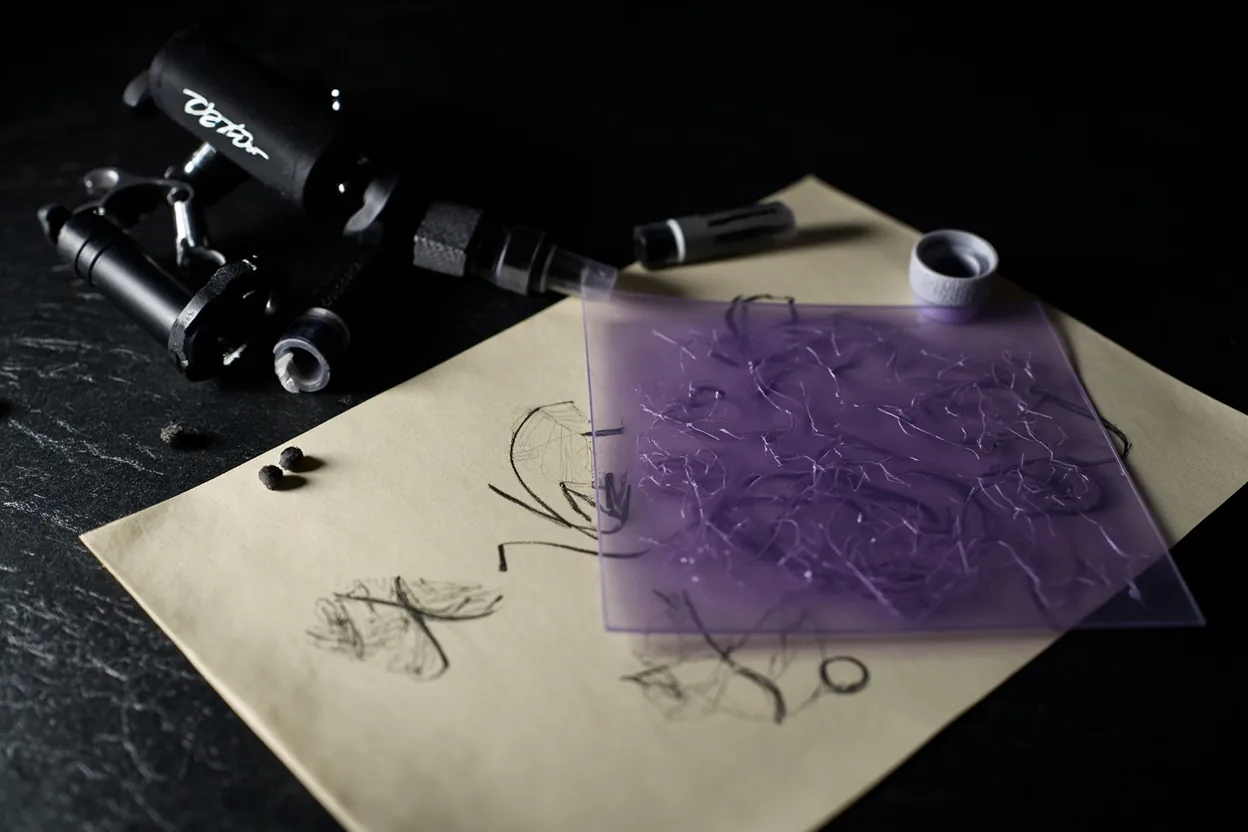 Custom tattoo design process sketches on studio table