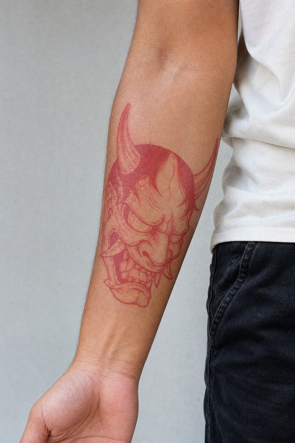 Red Ink Oni Mask Tattoo On Forearm