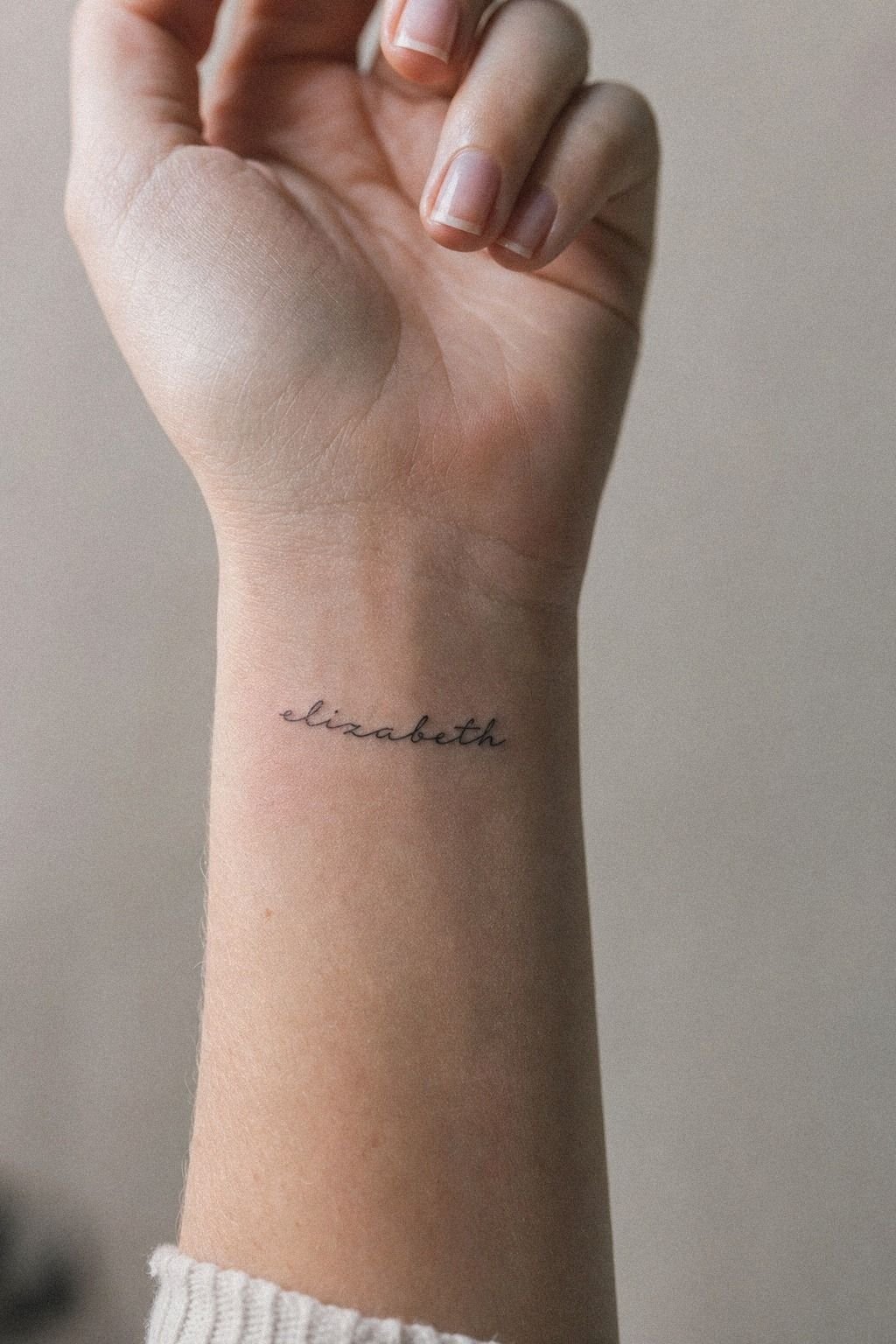 Fine Line Name Wrist Tattoo