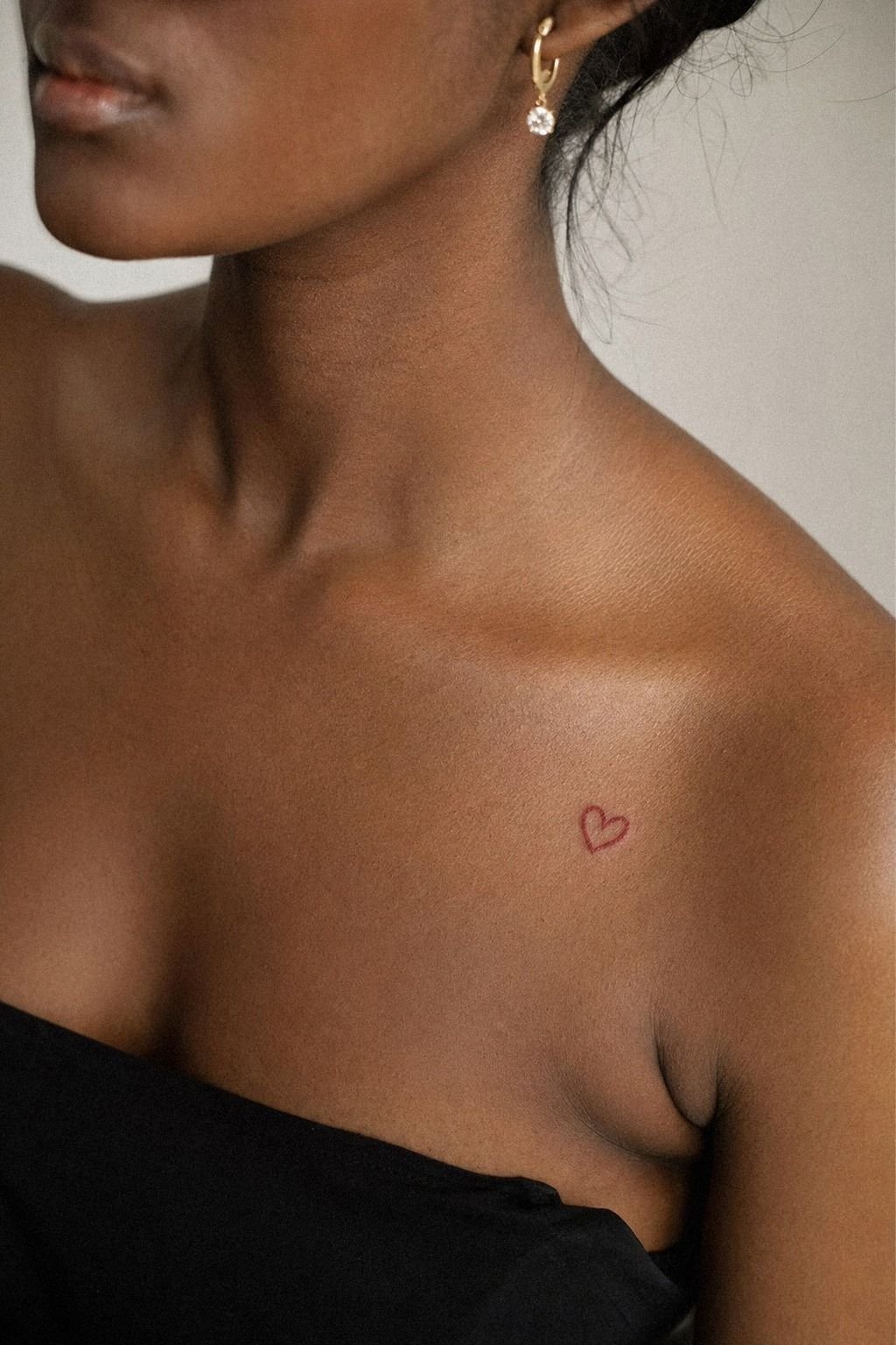 Red Ink Heart Tattoo On Collarbone