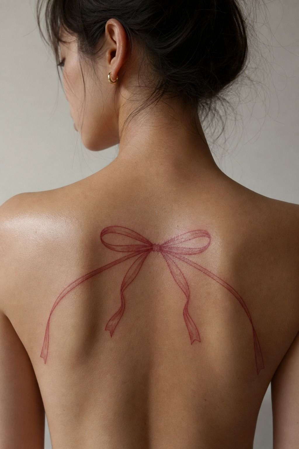 Small Red Ink Bow Back Tattoo