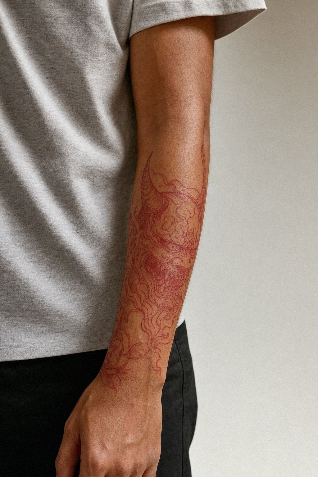 Red Ink Oni Tattoo On Forearm