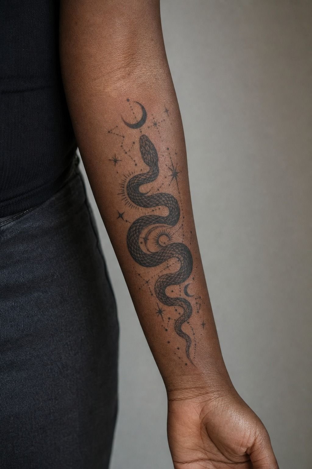 Pack Black Into a Celestial Snake Forearm Tattoo