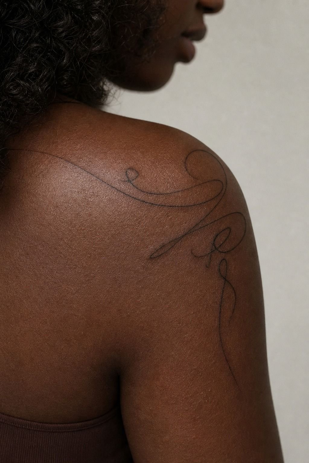 Script Tattoo Following the Shoulder’s Natural Curve