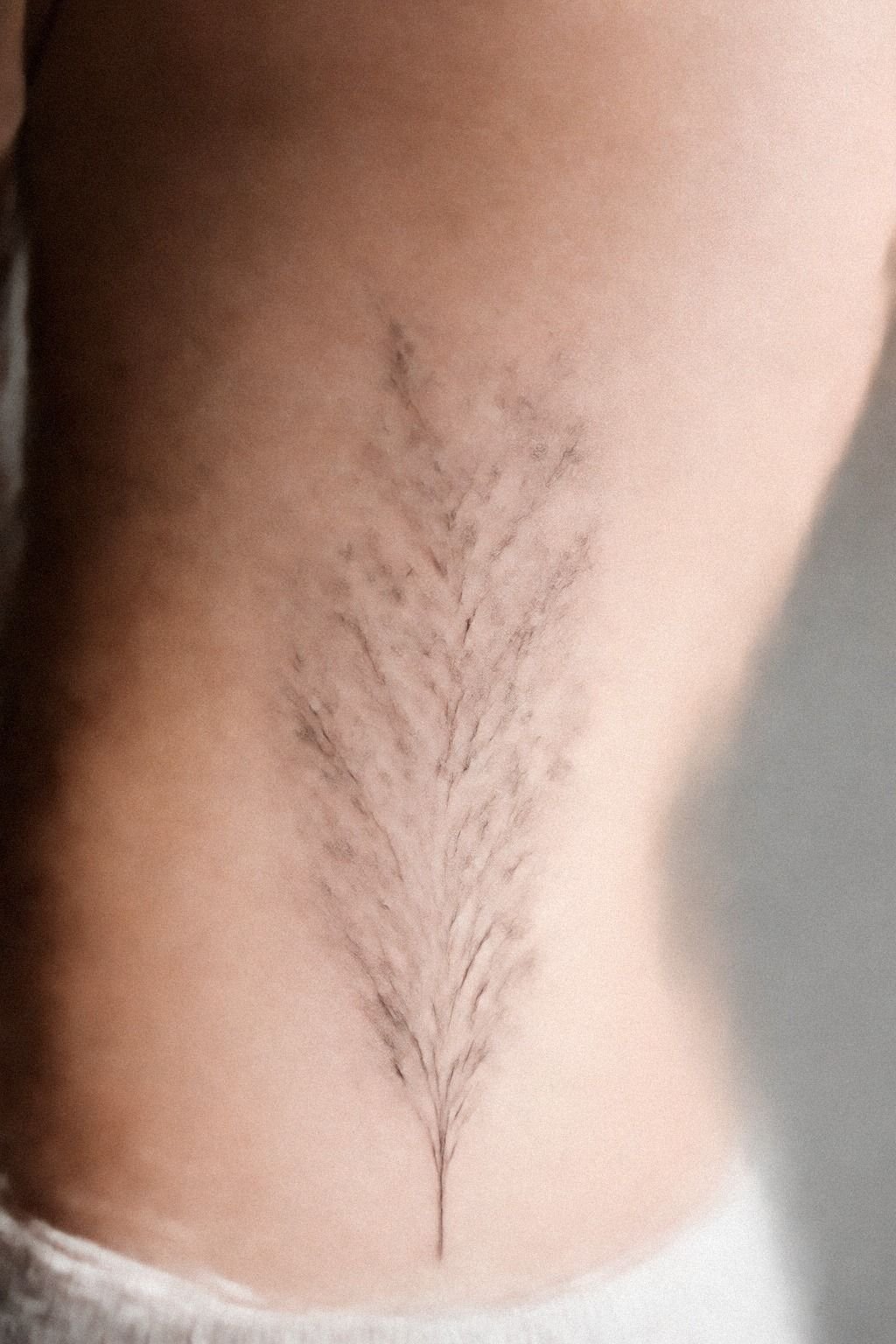 Delicate Rib Tattoo With Floral Detail