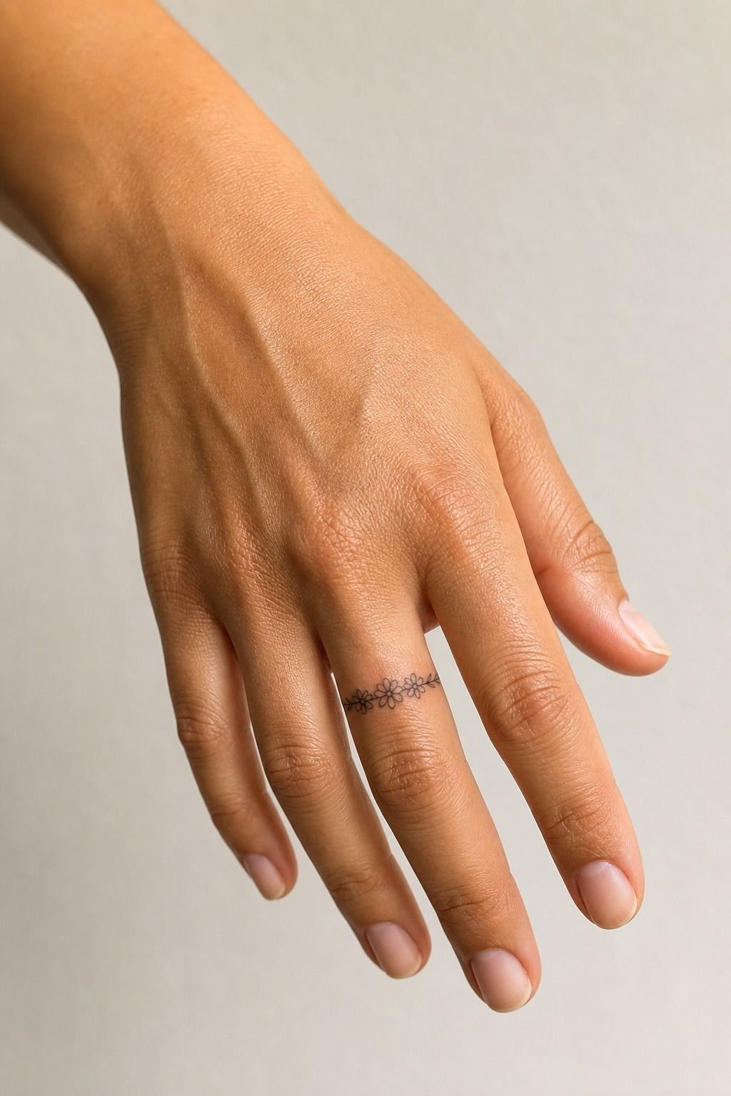 April Daisy Tiny Finger Tattoo