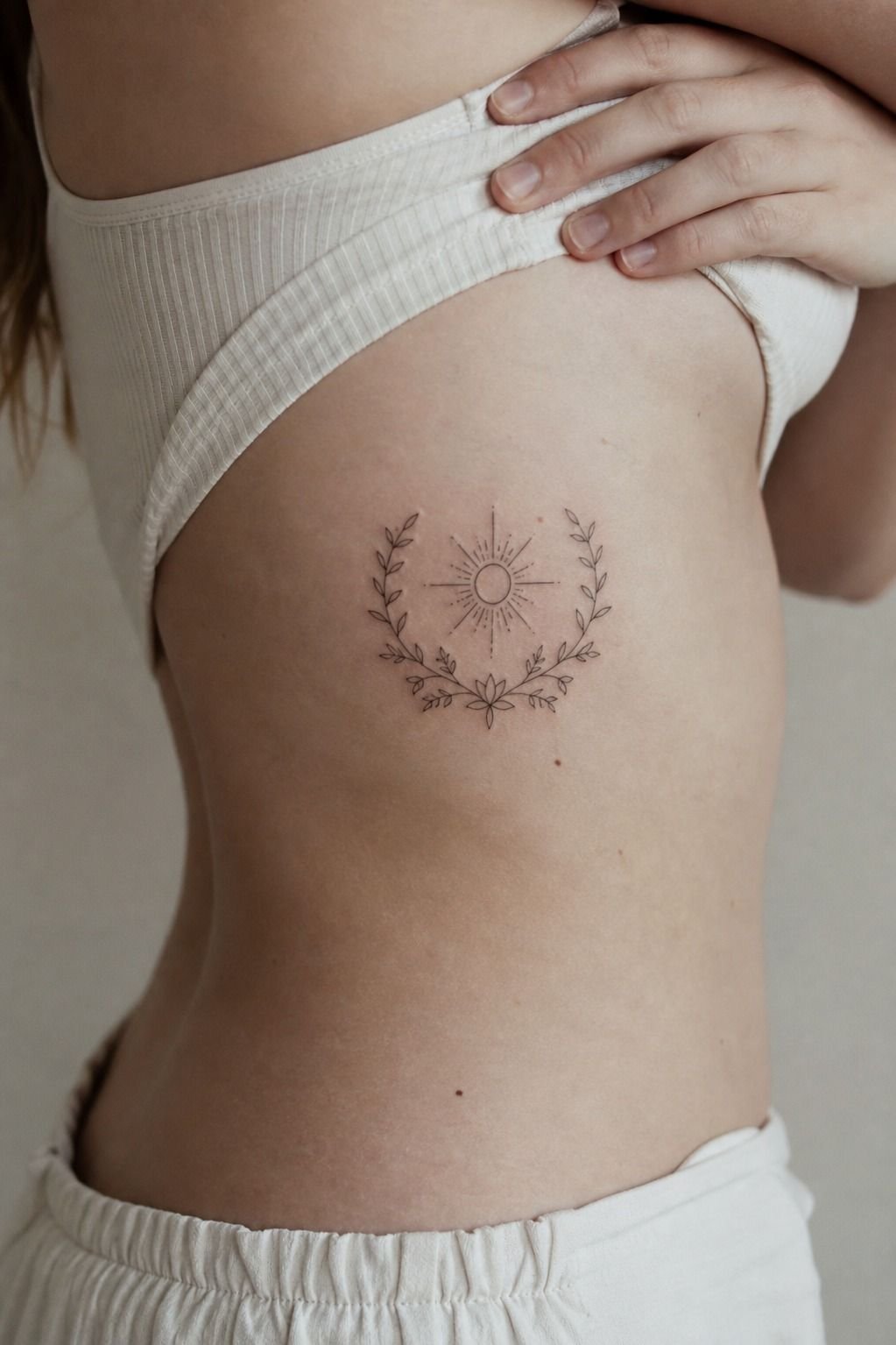 Sun Tattoo Framed By Botanical Leaves