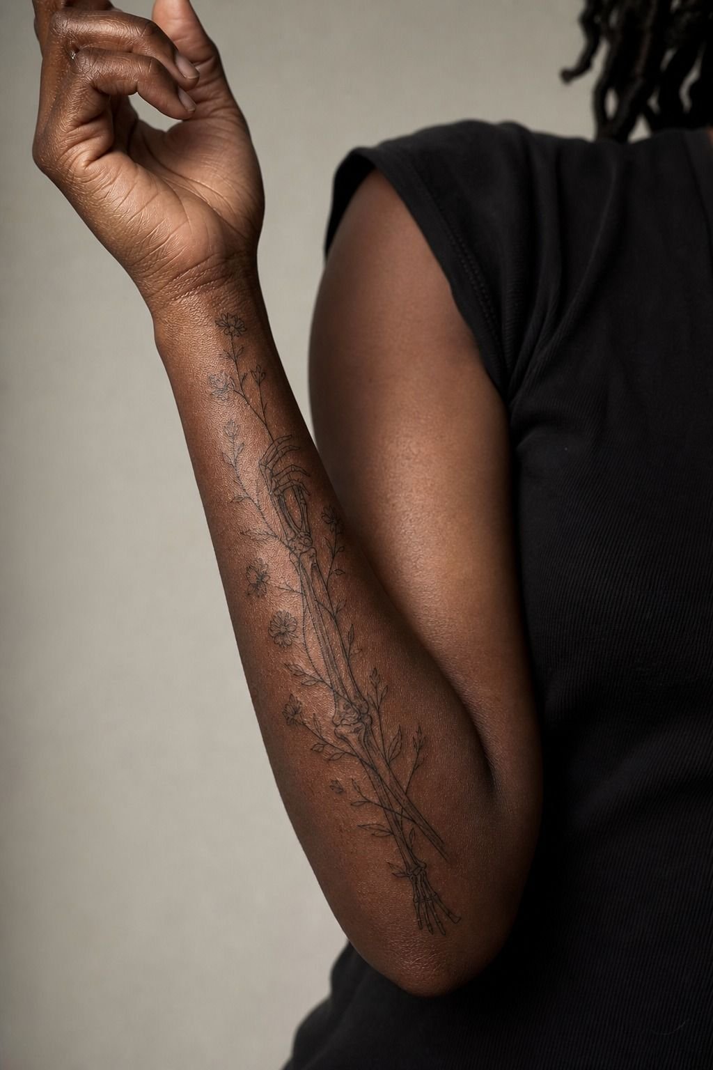 Skeleton Arm Tattoo With Wildflower Vines