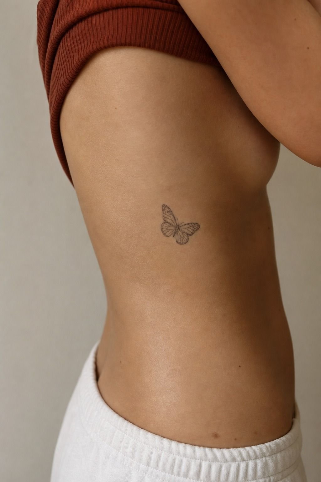 Small Butterfly Tattoo Following the Rib Curve