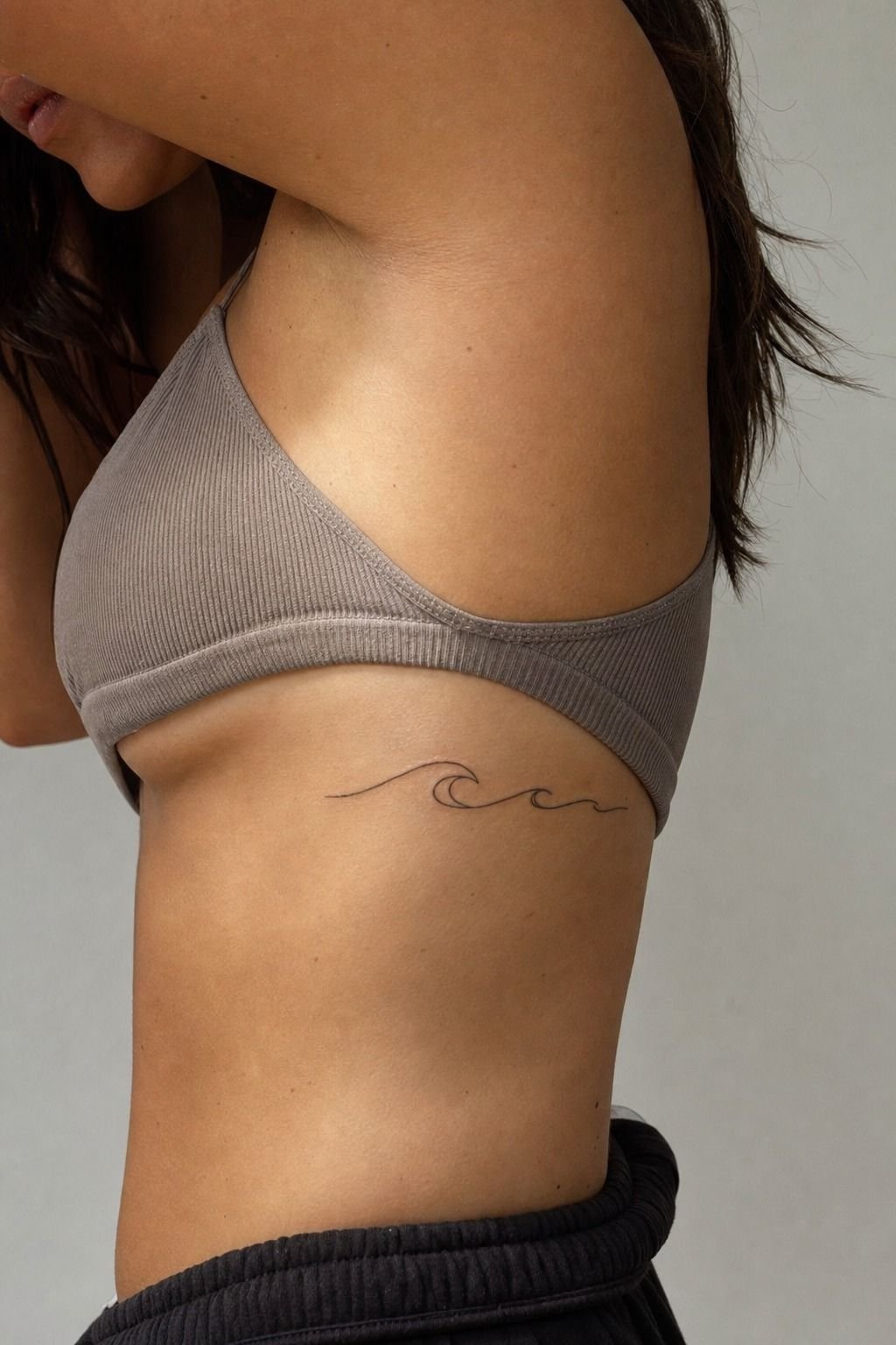 Tiny Wave Tattoo Beneath the Rib